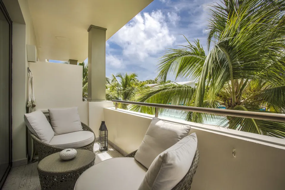 Privileged Romance Deluxe Junior Suite balcony seating with palms at Catalonia Royal Bavaro.
