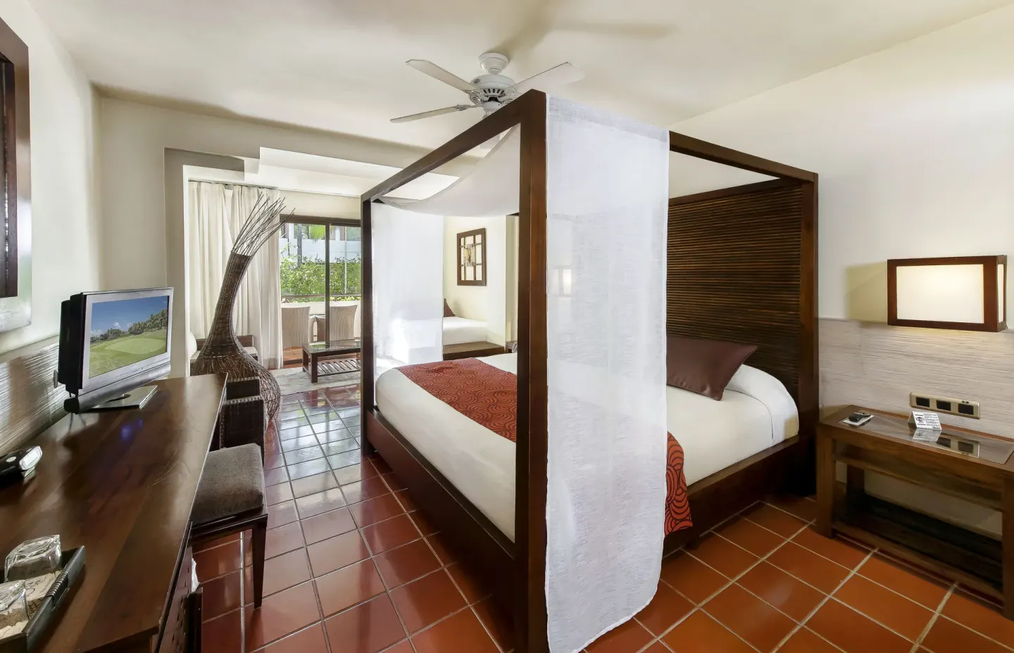 Superior Junior Suite canopy bed with TV console at Catalonia Royal Bavaro.