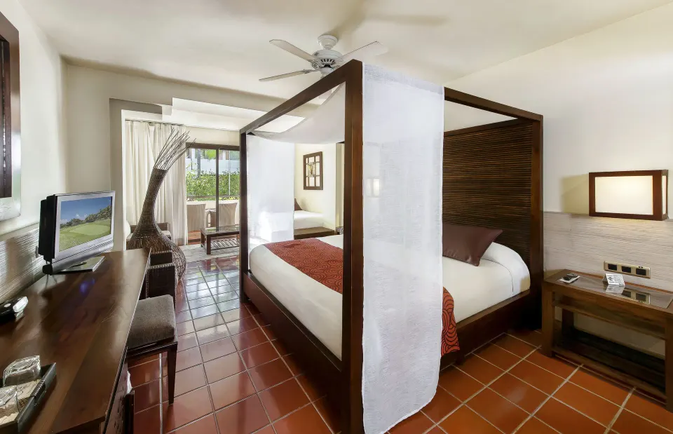 Superior Junior Suite canopy bed with TV console at Catalonia Royal Bavaro.
