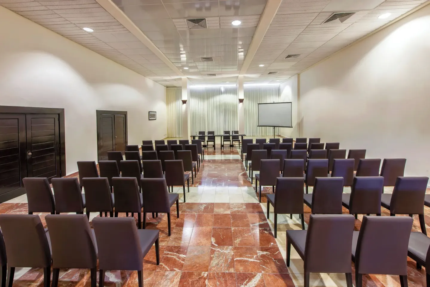 Meeting room with theater-style chairs and a projection screen at Catalonia Royal Bavaro.