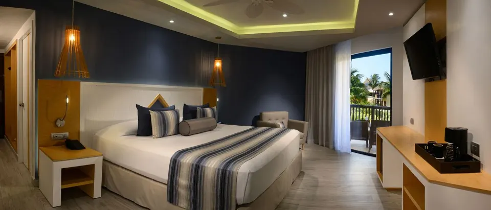 Balcony guest room with king bed and resort view at Catalonia Yucatan Beach
