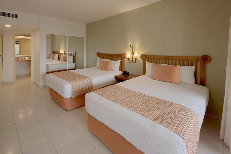 Classic twin-bed guest room with wood headboards at Catalonia Yucatan Beach
