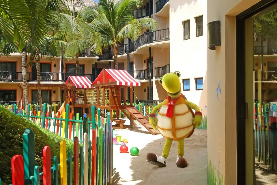 Resort playground and costumed turtle mascot on courtyard at Catalonia Yucatan Beach