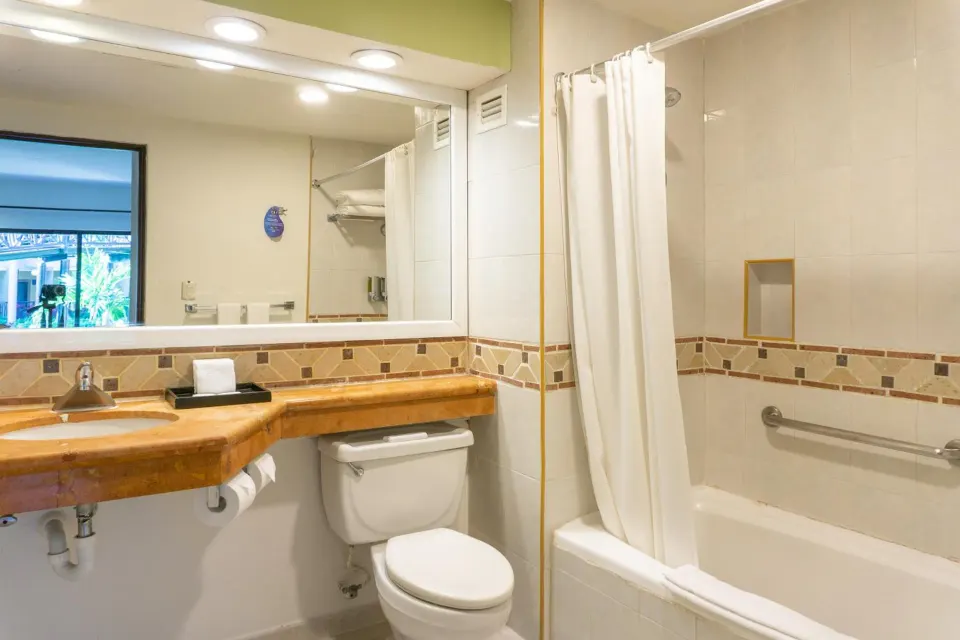 Bathroom with vanity, toilet and tub in a guest room at Catalonia Yucatan Beach