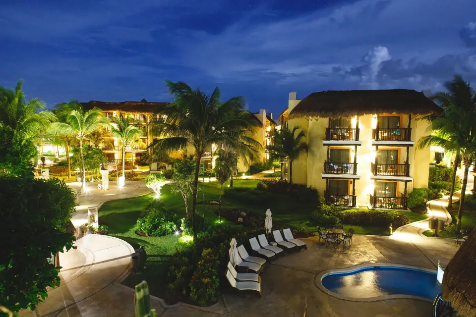 Resort grounds and illuminated pool area at night at Catalonia Yucatan Beach
