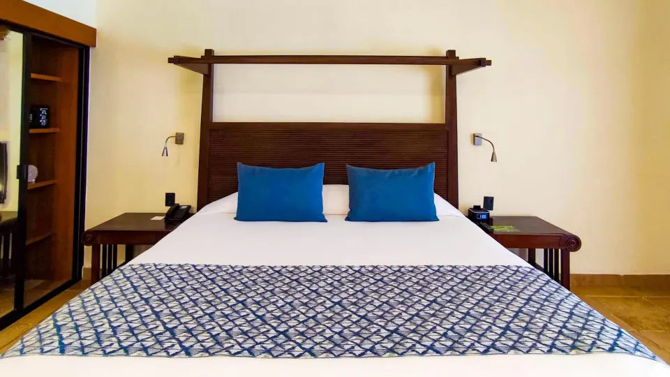 King bedroom with orange accent wall at Catalonia Yucatan Beach.