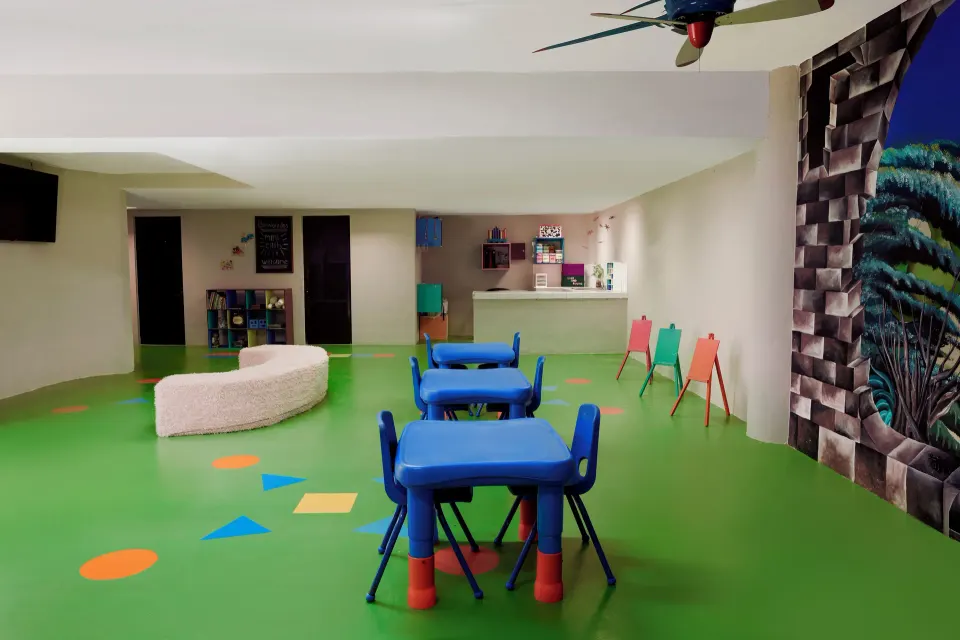 Indoor kids' playroom with small tables and colorful floor at Catalonia Yucatan Beach