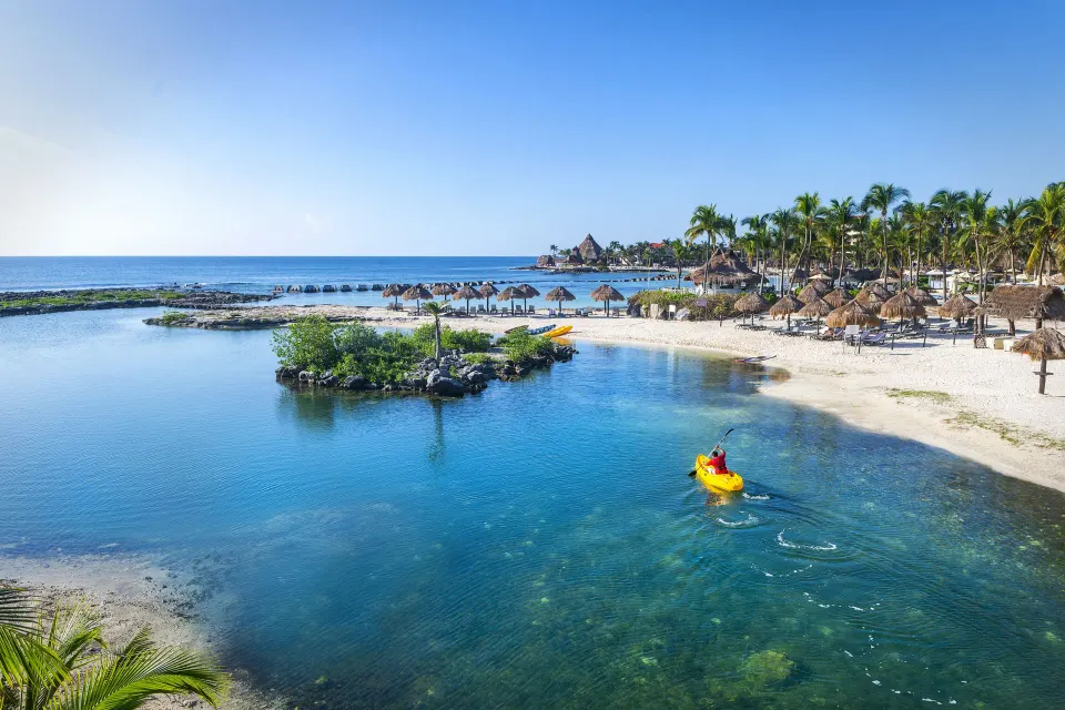 Resort lagoon and beachfront with palapas at Catalonia Yucatan Beach