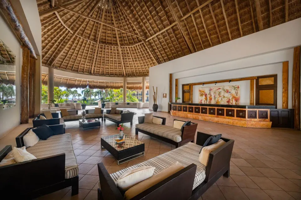 Open-air lobby under a large palapa roof at Catalonia Yucatan Beach
