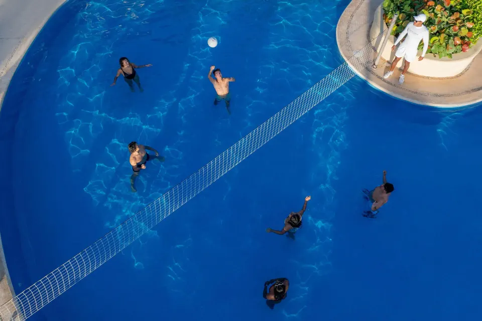 Guests playing volleyball in the resort pool at Catalonia Yucatan Beach.