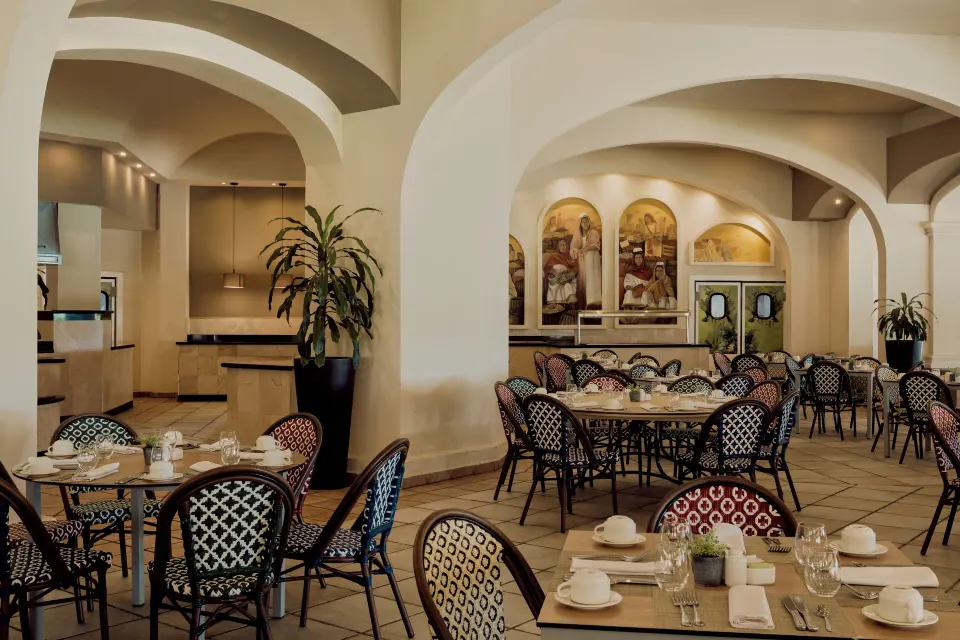 Indoor dining room with arched ceilings and set tables at Catalonia Yucatan Beach