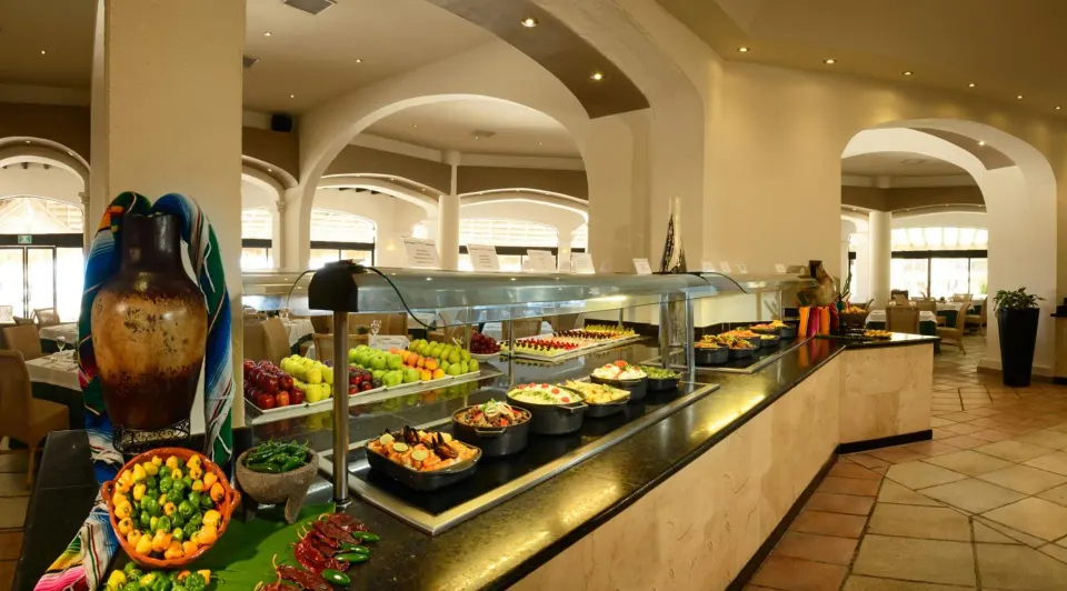 Buffet station with fruit and hot dishes in a resort dining room at Catalonia Yucatan Beach