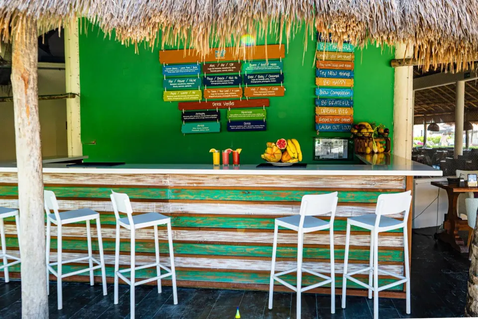 Close-up of a palapa bar counter with stools at Catalonia Yucatan Beach