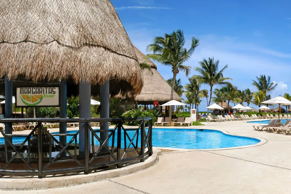 Thatched-roof pool bar and curved pool deck at Catalonia Yucatan Beach.