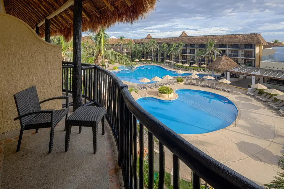Room balcony overlooking pool and grounds at Catalonia Yucatan Beach