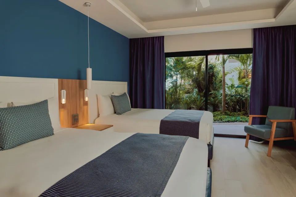 Premium Deluxe Room at Catalonia Yucatan Beach with two double beds and garden view patio.