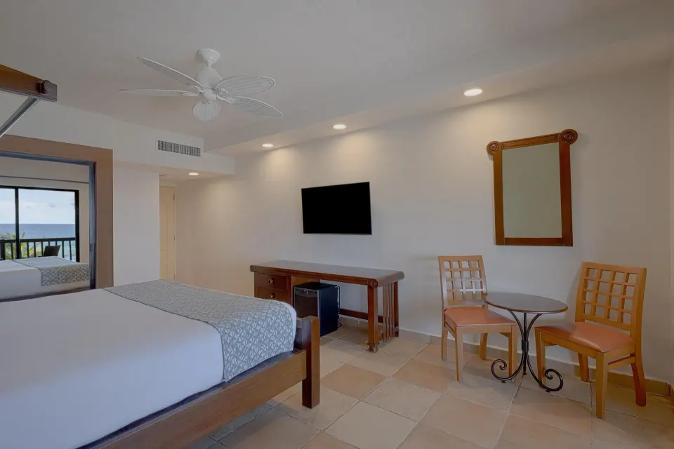 Premium Ocean Front Room interior with king bed and table at Catalonia Yucatan Beach
