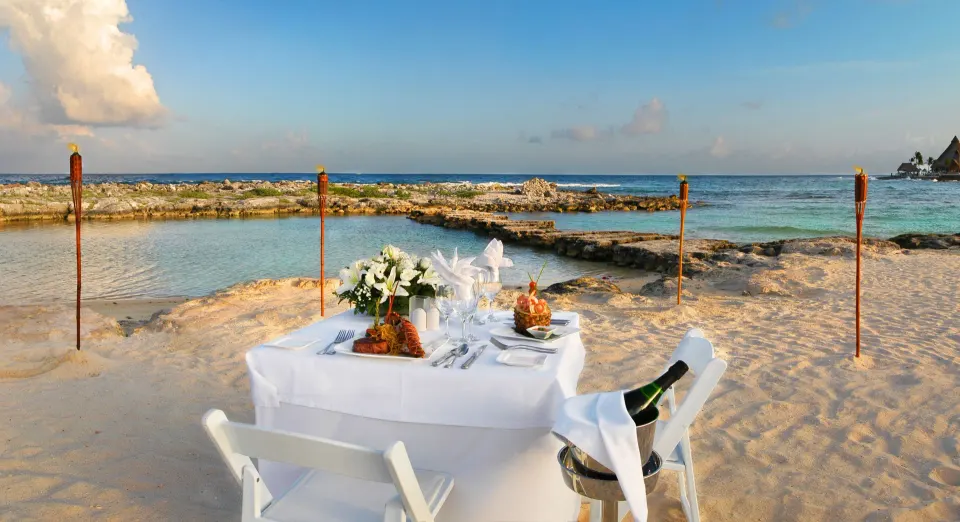 Romantic table set on the sand by the sea at Catalonia Yucatan Beach