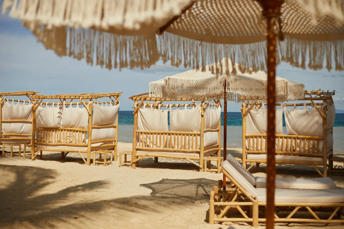 Bamboo beach cabanas and fringed umbrellas face the sea at Cayo Levantado Resort.