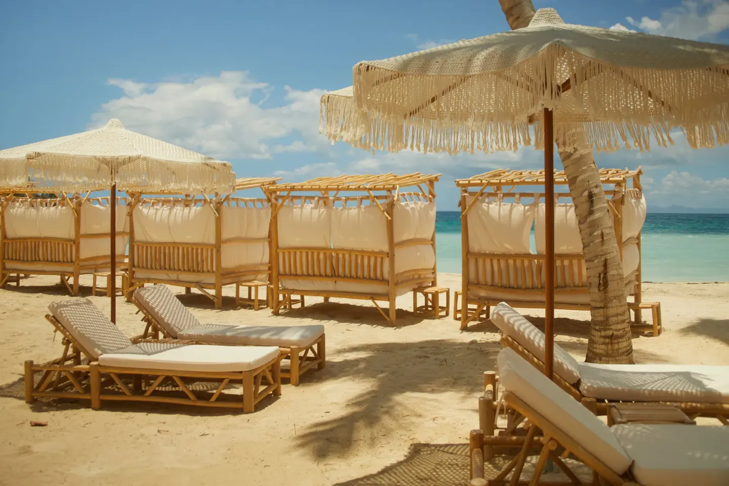 Fringed umbrellas shade loungers and bamboo cabanas at Cayo Levantado Resort.