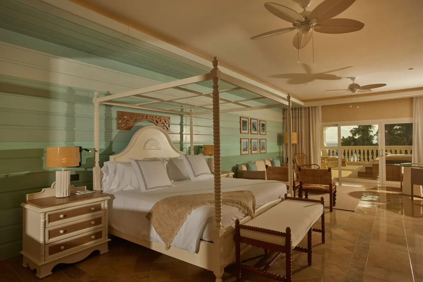 King canopy bed with seating area and balcony in a guest room at Cayo Levantado Resort.