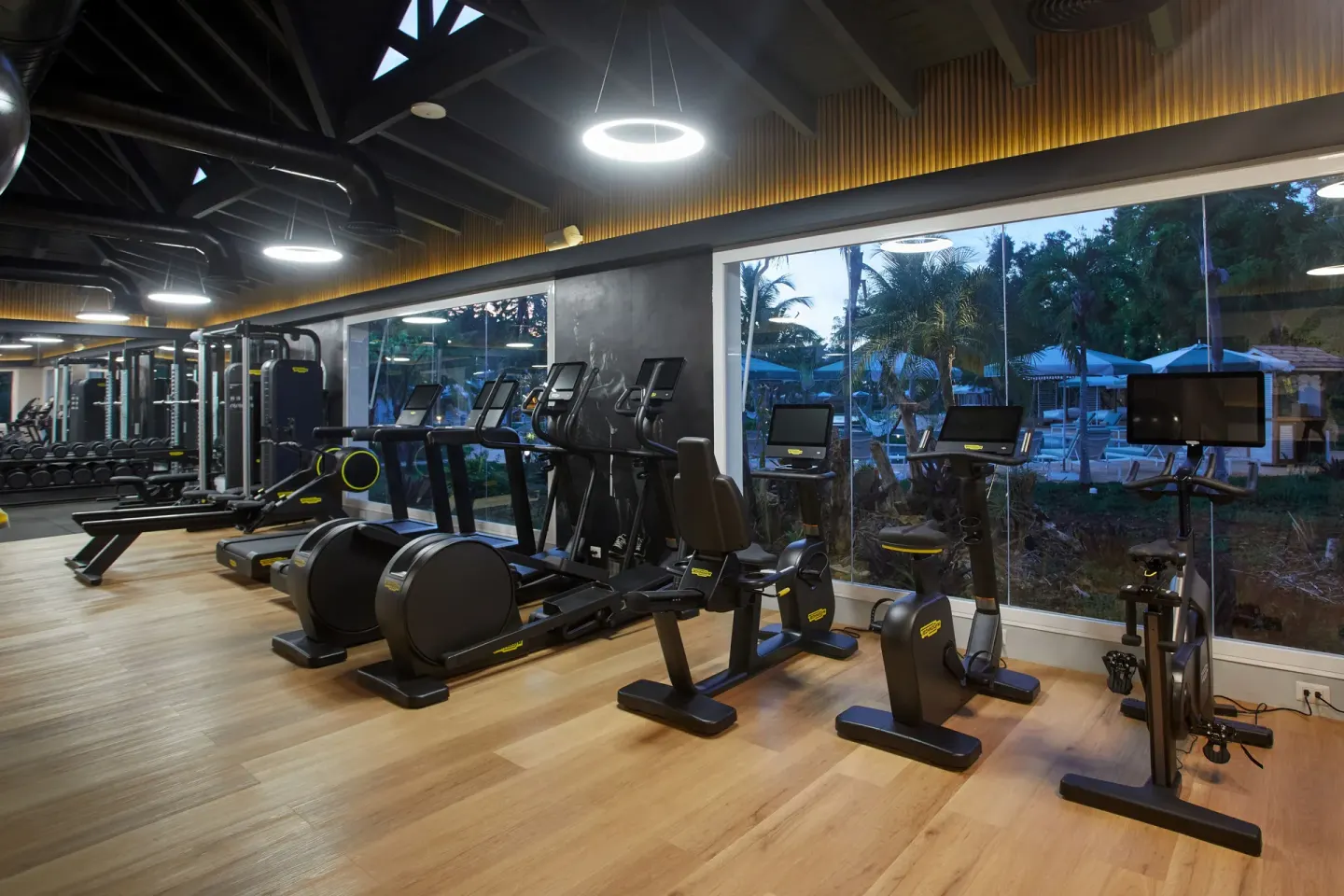 Indoor gym with cardio machines and poolside windows at Cayo Levantado Resort.