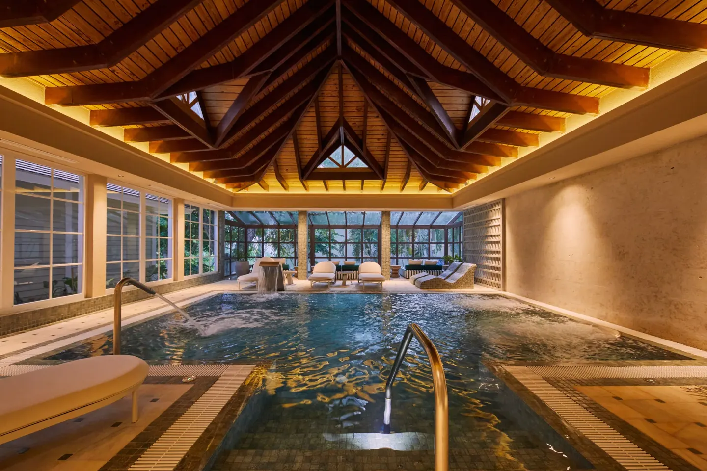 Indoor spa pool with loungers and wood ceiling at Cayo Levantado Resort.