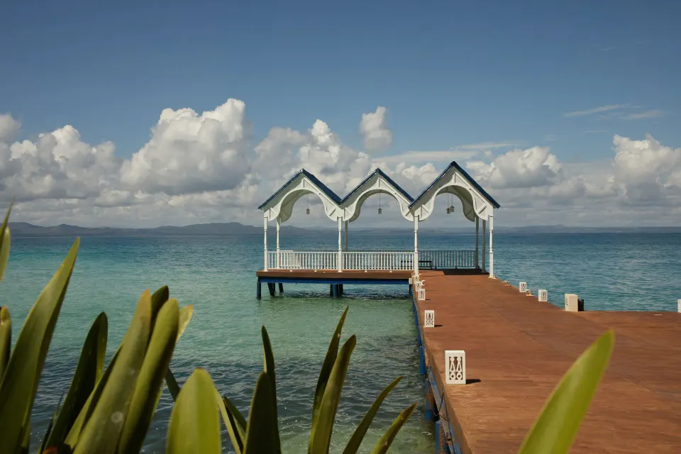 White pier pavilion over clear ocean water at Cayo Levantado Resort.