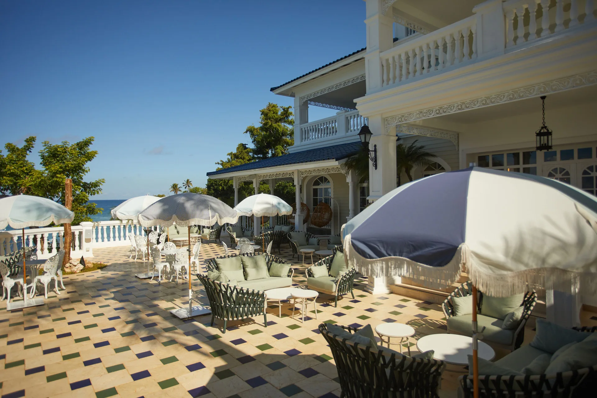 Sunlit terrace with umbrellas beside a white resort building at Cayo Levantado Resort.