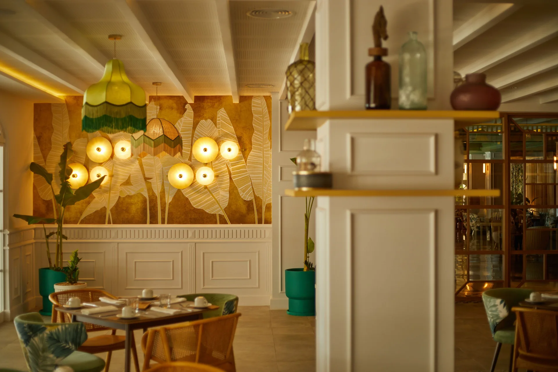 Bright dining room with leaf wall art and set tables at Cayo Levantado Resort.