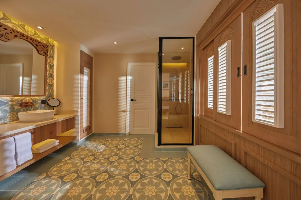 Junior Suite bathroom with vanity, shower, shutters, and patterned tile at Cayo Levantado Resort.