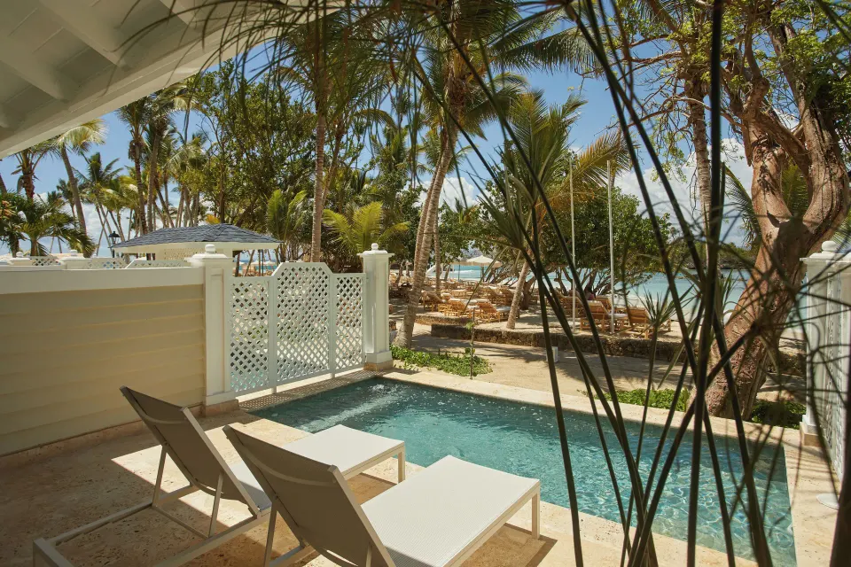 Oceanfront villa plunge pool and loungers behind palms at Cayo Levantado Resort.