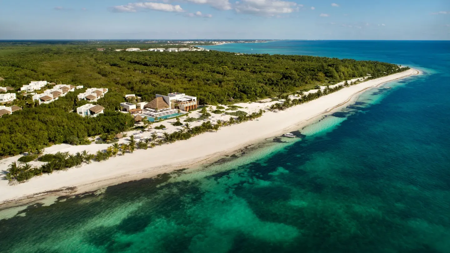 An aerial view shows Chablé Maroma along a white beach and turquoise sea.