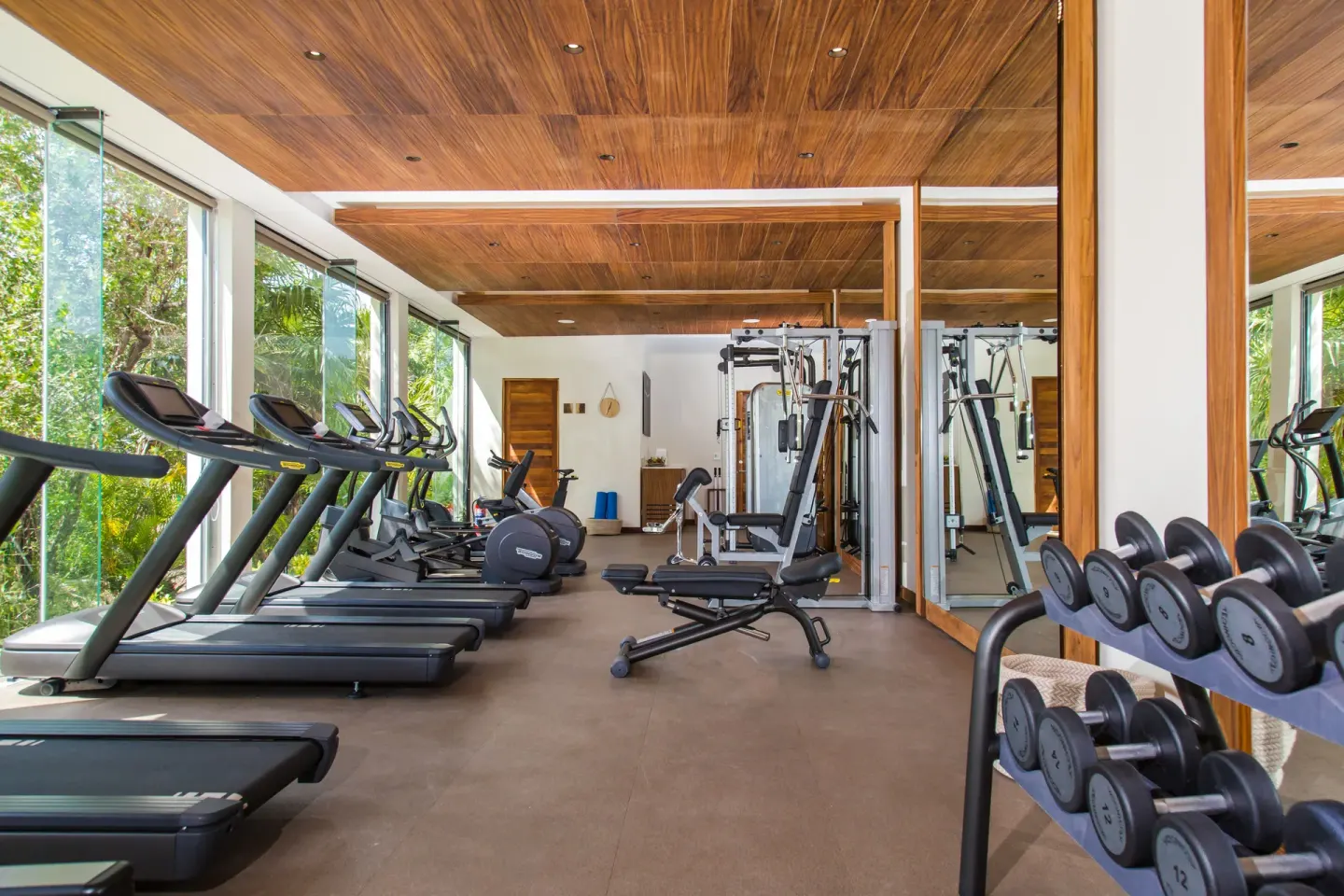 Fitness center with treadmills, weights, and jungle views at Chablé Maroma.