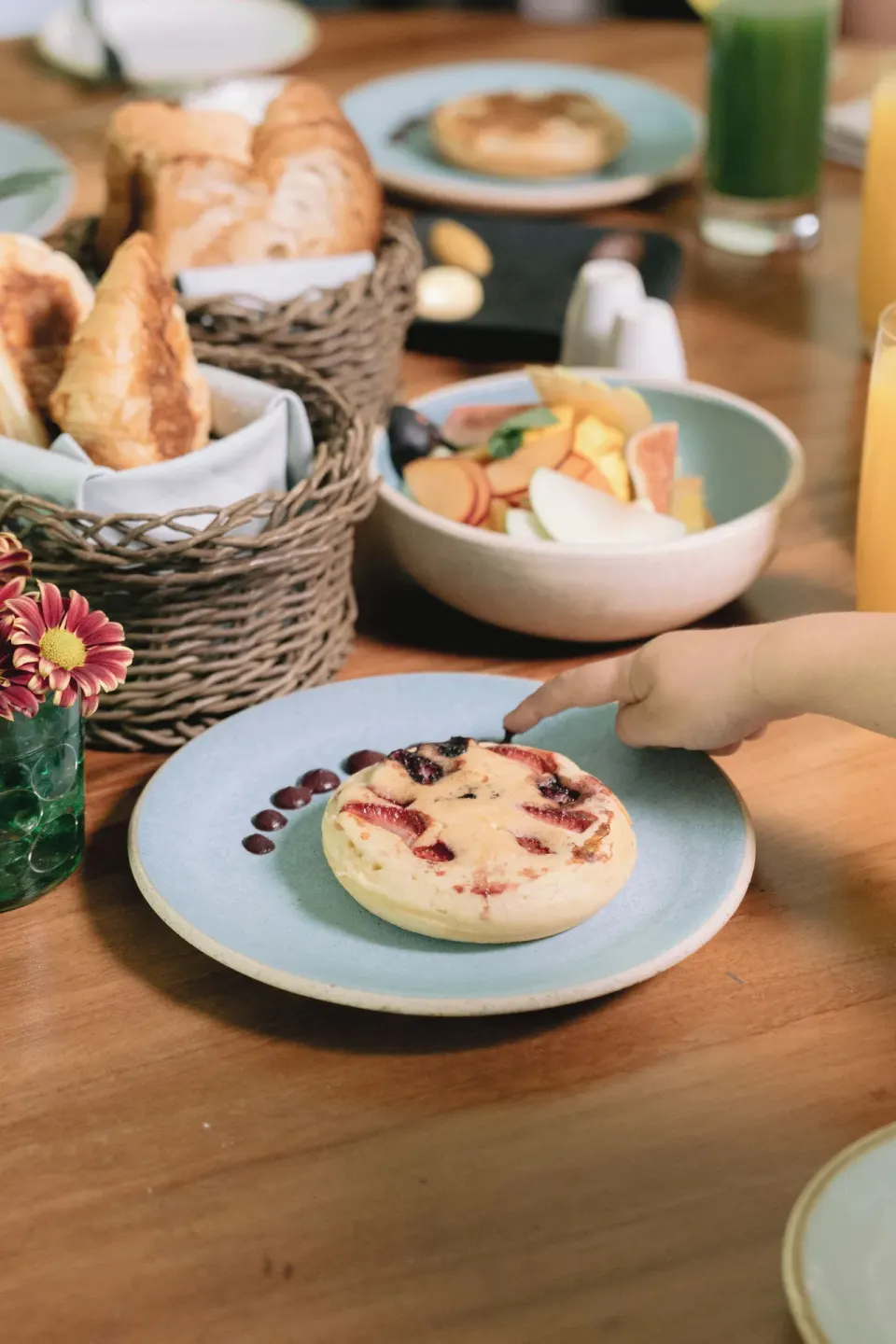 Pastries and fruit bowls on a wooden breakfast table at Chablé Maroma