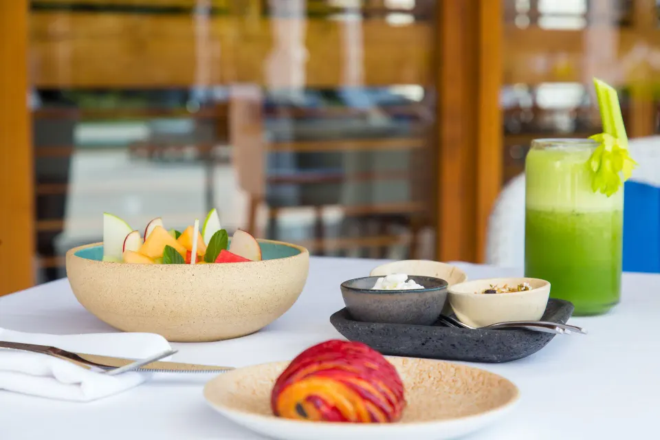 Breakfast spread with fruit bowl and green juice at Chablé Maroma
