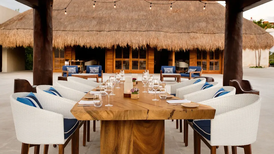 Outdoor palapa dining table with white chairs at Chablé Maroma