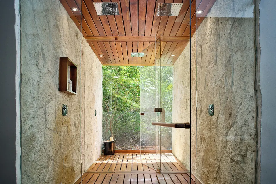 Glass-enclosed wooden floored shower with rainforest view in the Presidential Villa at Chablé Maroma.