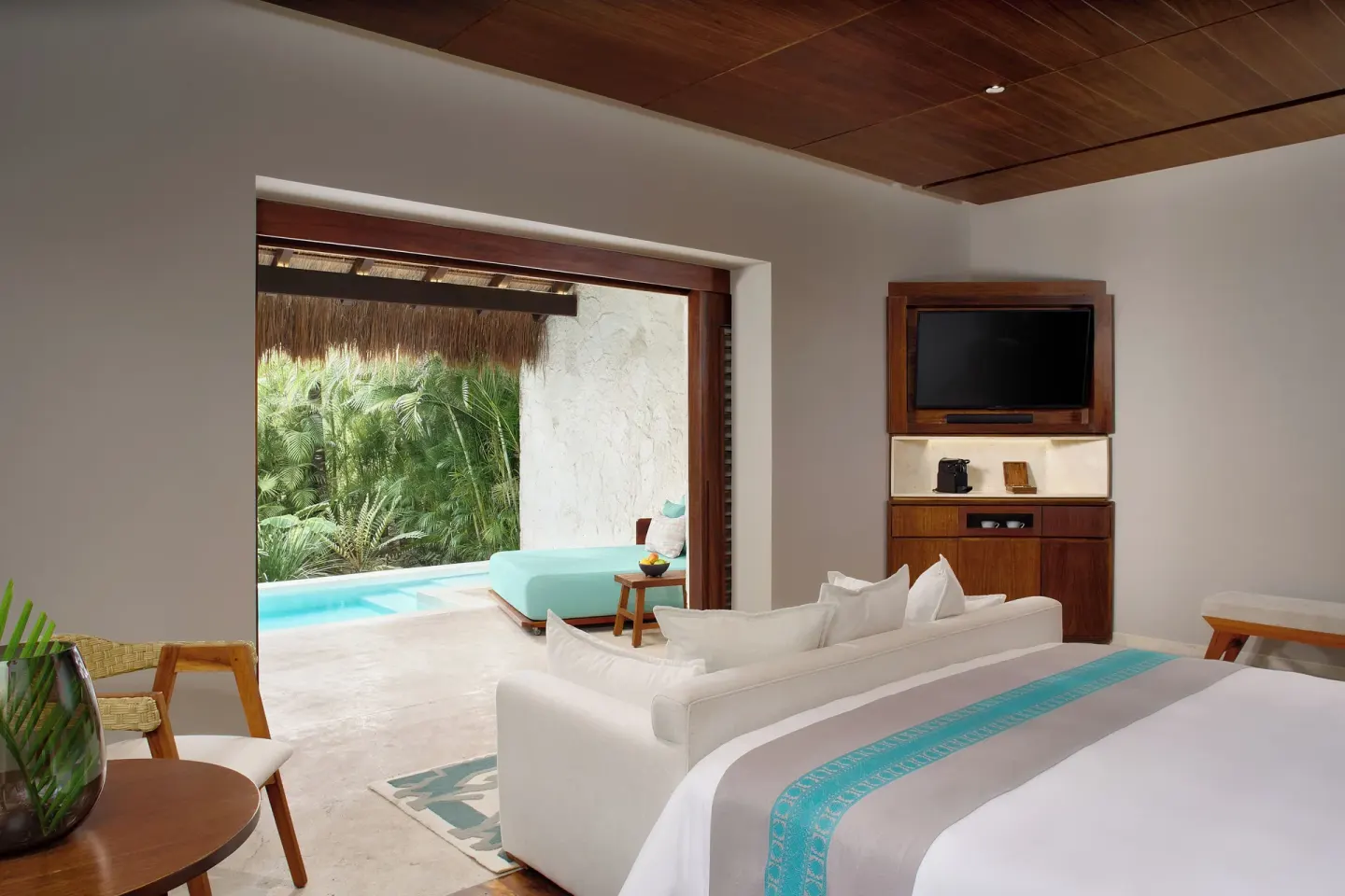Treetop Pool Villa king bed and sitting area opening to the pool at Chablé Maroma.
