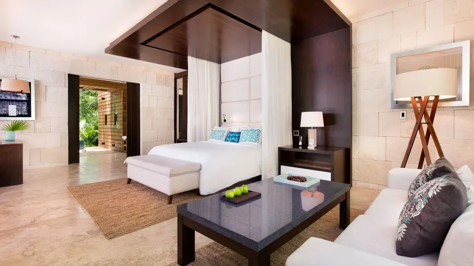 Canopy king bed and seating area in a suite bedroom at Chablé Yucatán