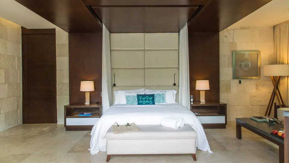 King bed with canopy and bedside tables in a guest room at Chablé Yucatán