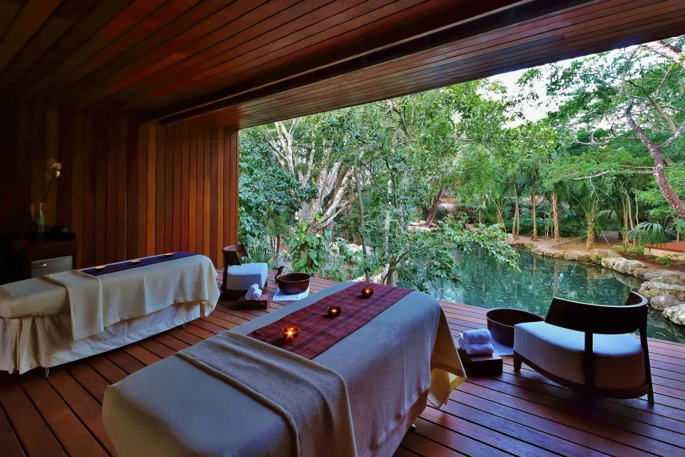 Spa treatment room with twin massage tables facing a jungle cenote at Chablé Yucatán