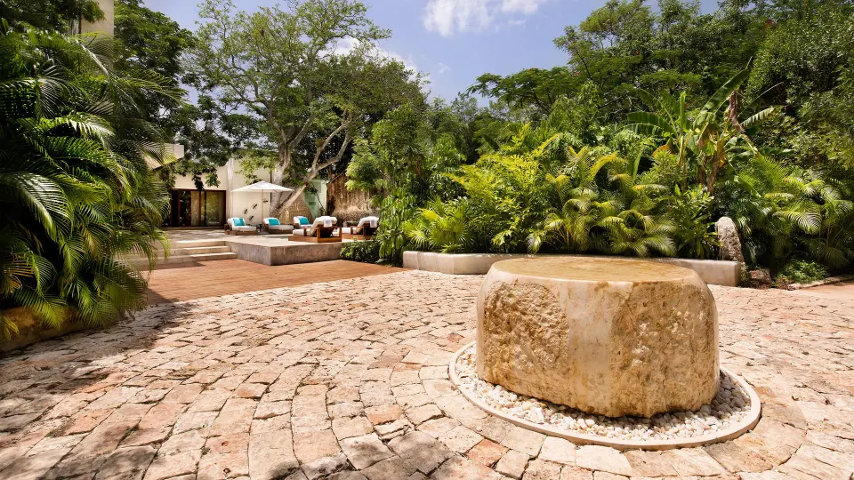 Stone courtyard fountain and tropical landscaping at Chablé Yucatán
