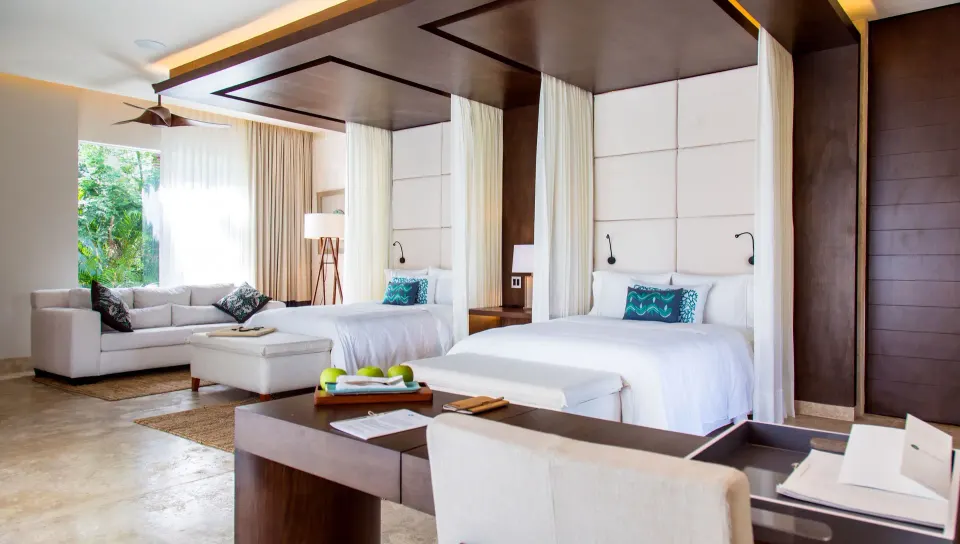 Twin beds and seating area in a spacious guest room at Chablé Yucatán
