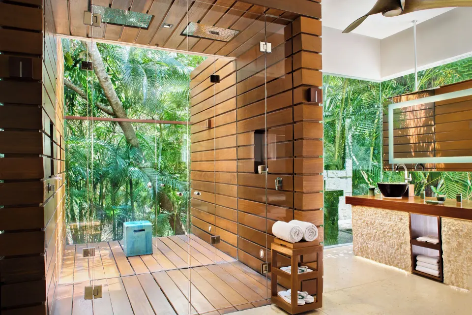 Bathroom with glass-enclosed wooden shower and tropical views at Chablé Yucatán