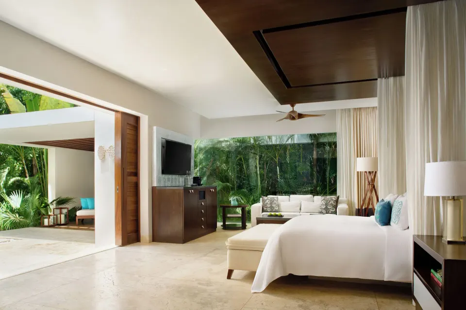 Suite interior showing king bed, sofa and open patio at Chablé Yucatán