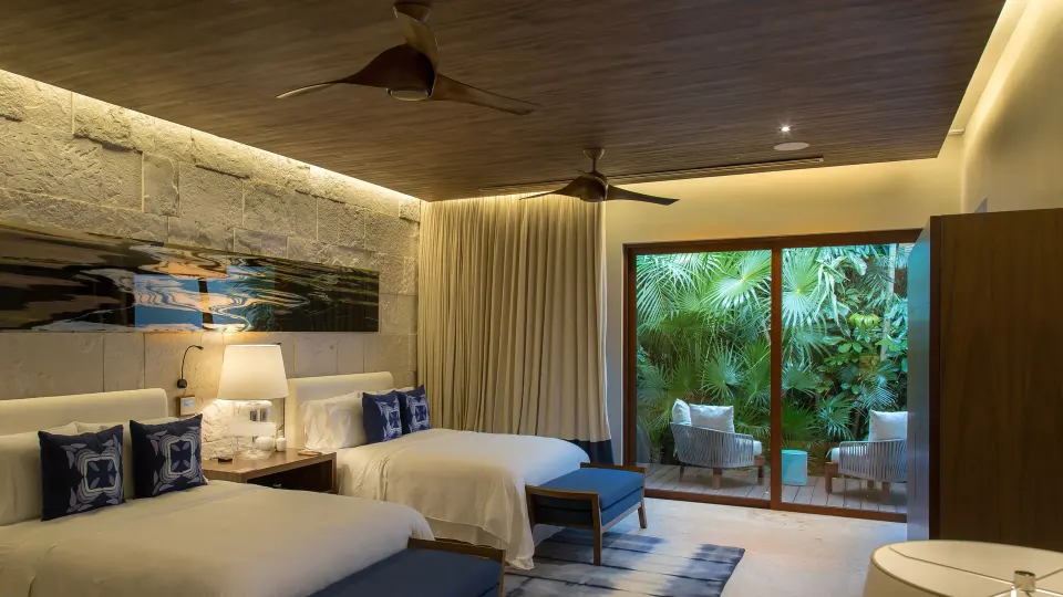 Twin bed guest room with patio and tropical greenery at Chablé Yucatán