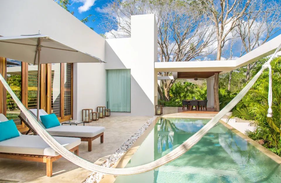 Outdoor pool terrace with hammock and loungers at Chablé Yucatán