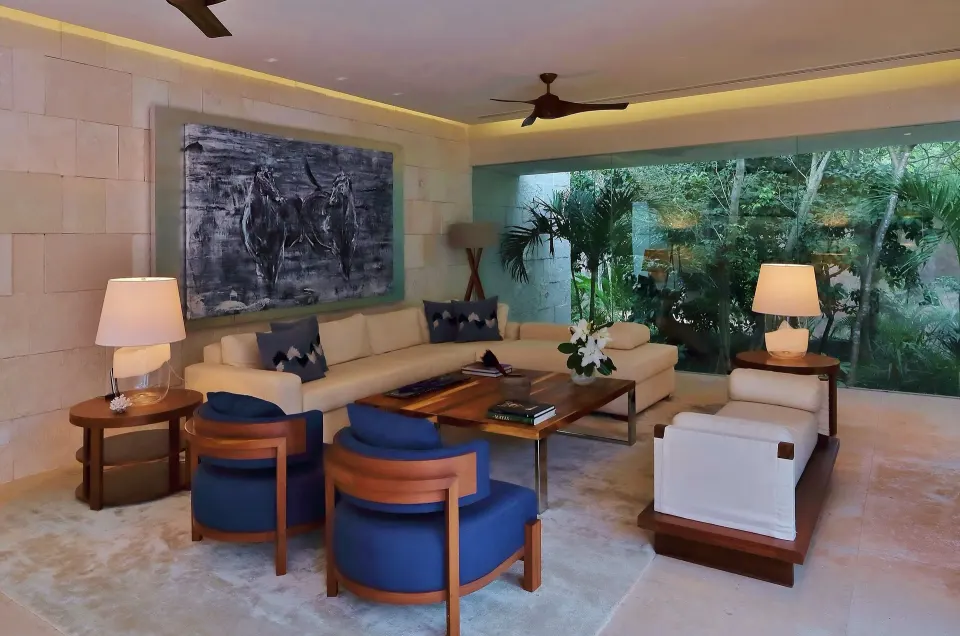 Spacious living room with sofa, blue chairs and jungle view at Chablé Yucatán