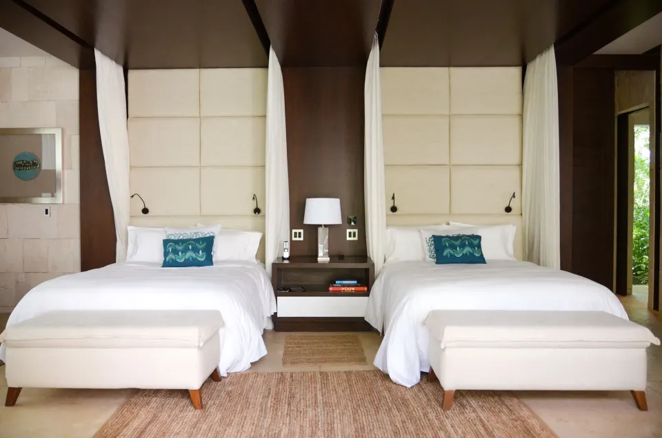 Elegant twin bedroom with canopy details and neutral decor at Chablé Yucatán